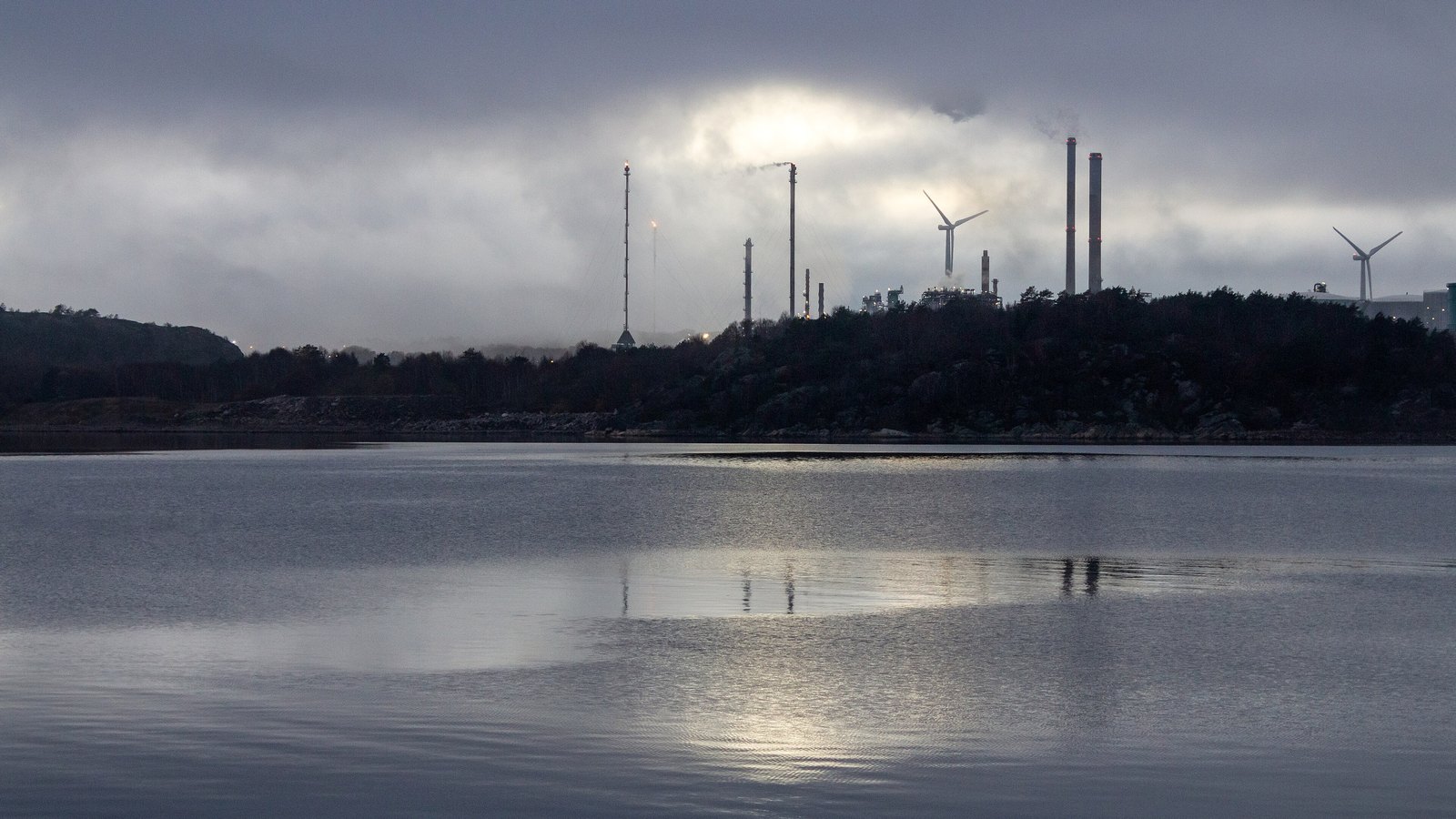 An oil refinery with processing towers in fog